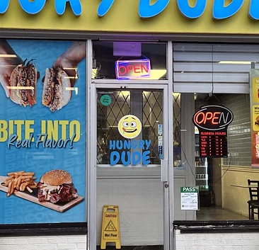 The Hungry Dude entrance with the emoji face and logo on the door